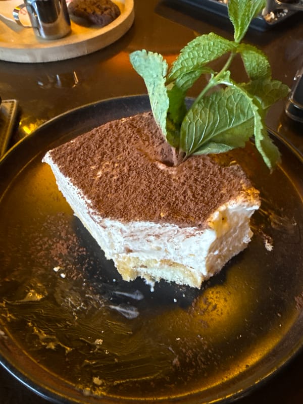 Tiramisu slice with mint garnish, plated in Yerevan