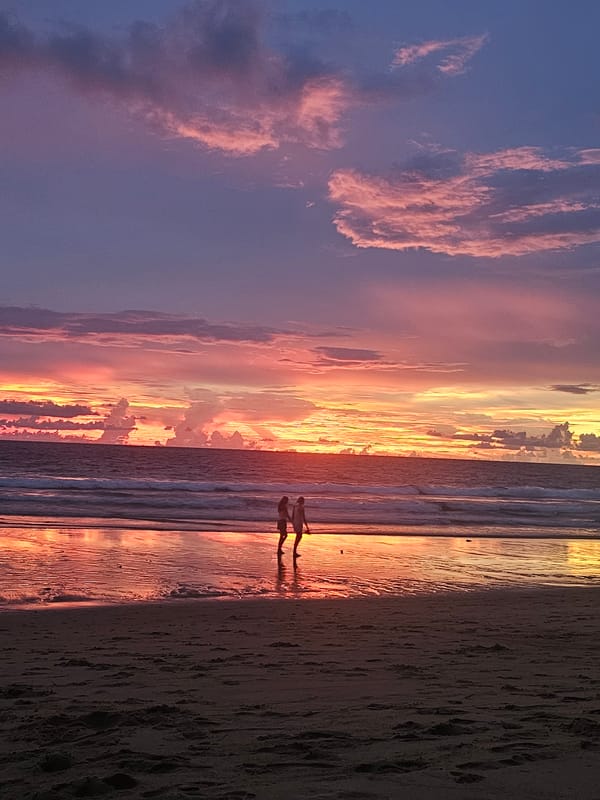 Beach sunset in Sakhu, Thailand, with people unwinding at dusk