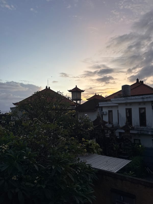Traditional Balinese buildings captured under dramatic yellow-lit sky in Kuta