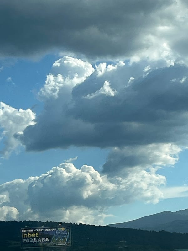 Highway drive through mountains under dramatic summer skies