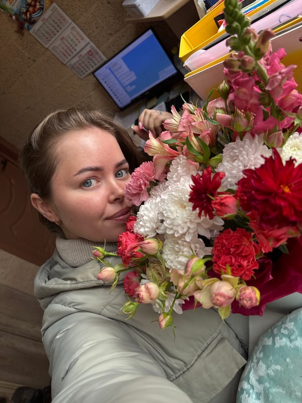 Woman poses with flower bouquet in Russian village