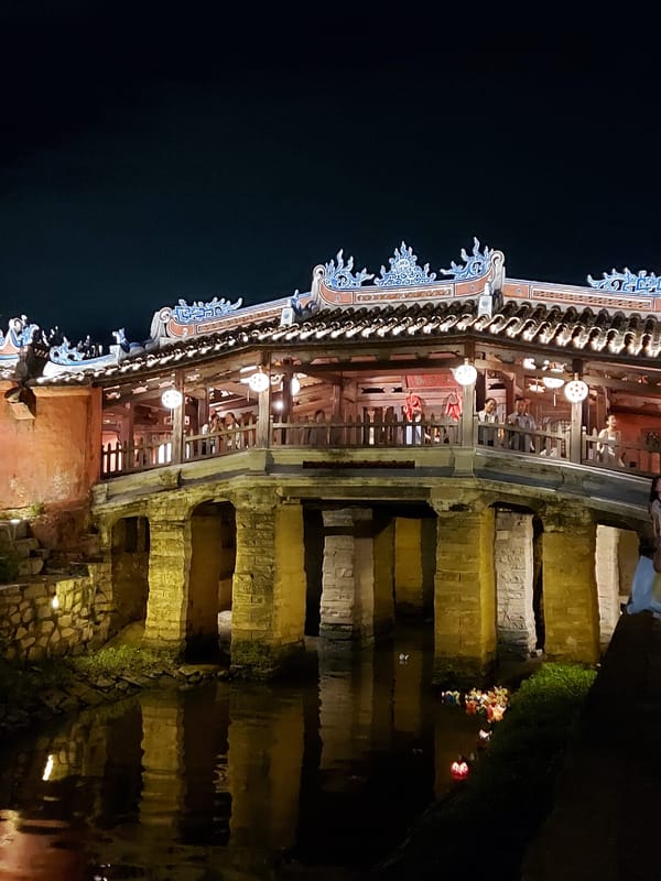 Hoi An's Japanese Covered Bridge glowing over the Thu Bon River at night