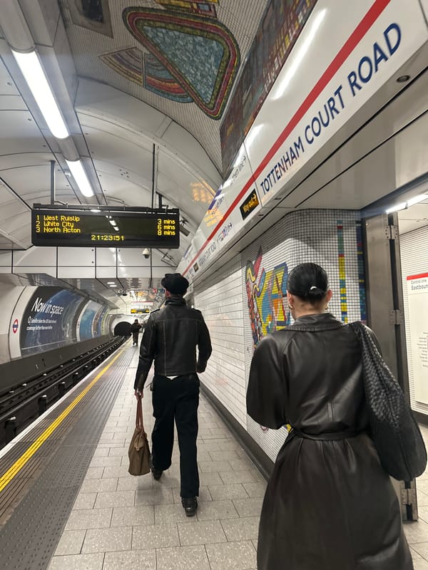 Woman takes selfie at London Underground station near beauty ads