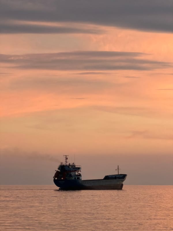 Cargo ship and sailboat silhouetted at dusk off Bar, Montenegro