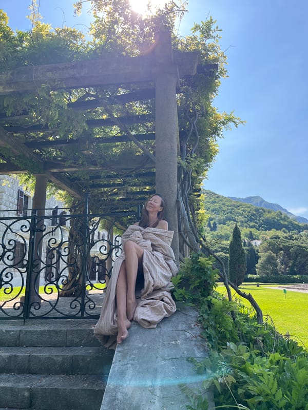 Woman rests in stone garden at Sveti Stefan