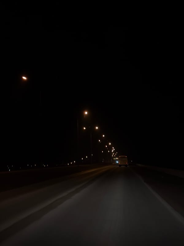 Vehicle travels illuminated highway in Chaikovsky, Russia