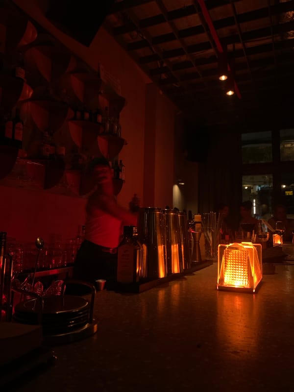 Red-lit bar interior glowing with caged lanterns, Tel Aviv