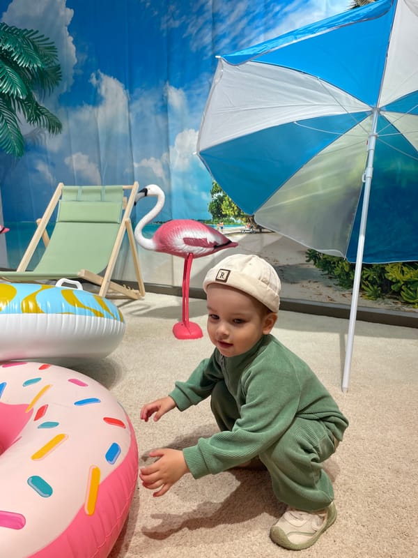 Child reaches for pink inflatable donut during playtime