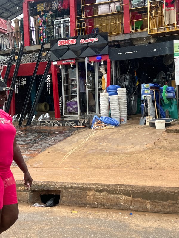Busy street day outside Desmond Boutique in Okpanam, Nigeria