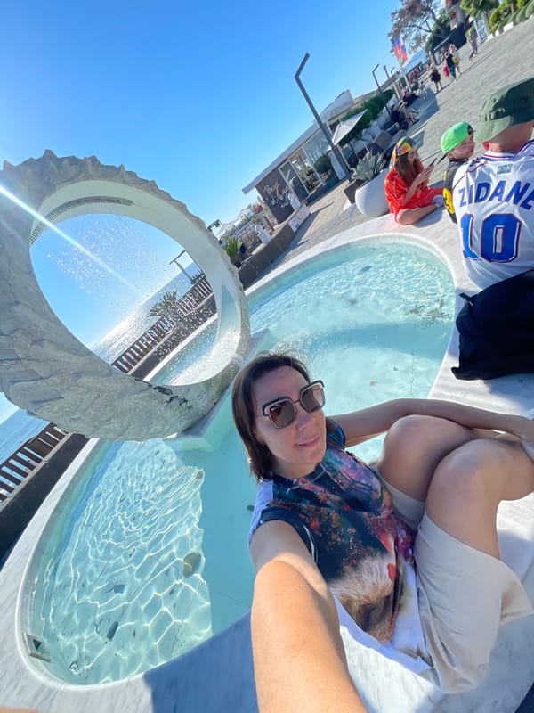 Woman enjoys sunny afternoon at Sochi waterfront cafes and fountains