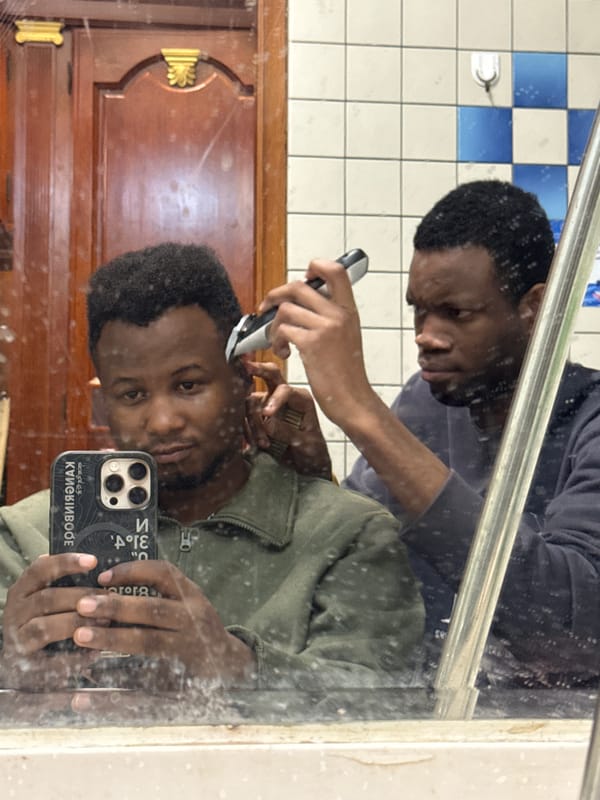 Friends give haircuts in Daxing District bathroom