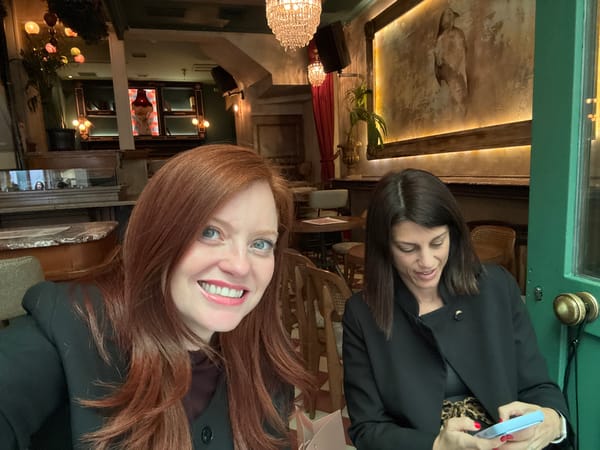 Two women photographed at Athens restaurant, one checking phone