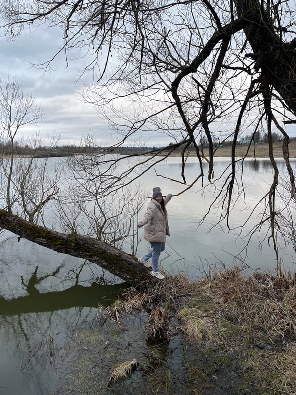Woman photographs spring outing by water in Zolino, Russia