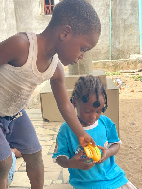 Children play with toys in courtyard, Badagry Nigeria