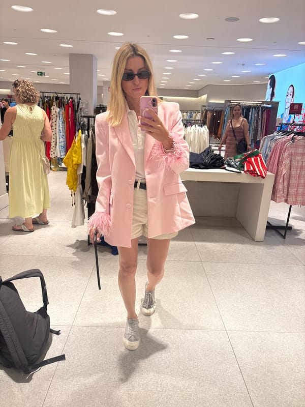 Trying on a feathered pink blazer in a Valencia boutique