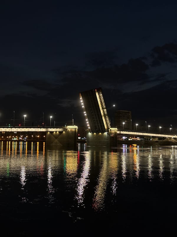 Drawbridge raises over the water at night in Otradnoye