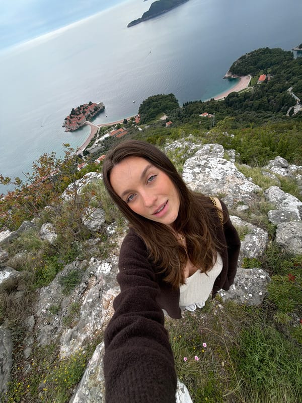 Woman takes selfie on rocks overlooking Adriatic in Montenegro