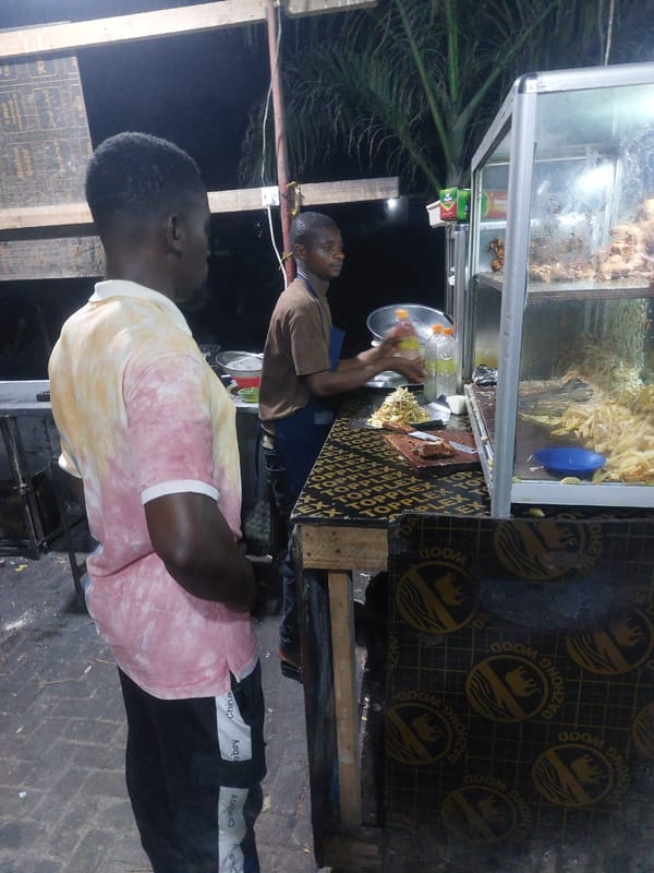 Street vendor prepares food at nighttime stall in Dar es-Salaam