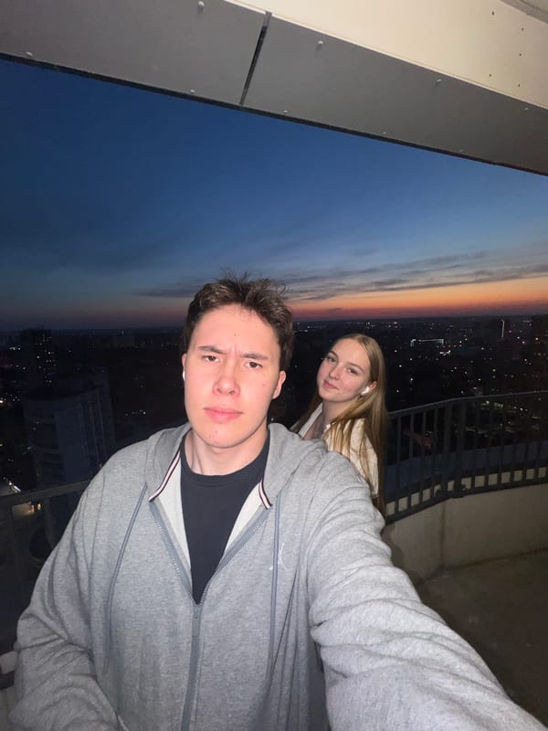 Couple photographs selfie on Perm balcony at dusk
