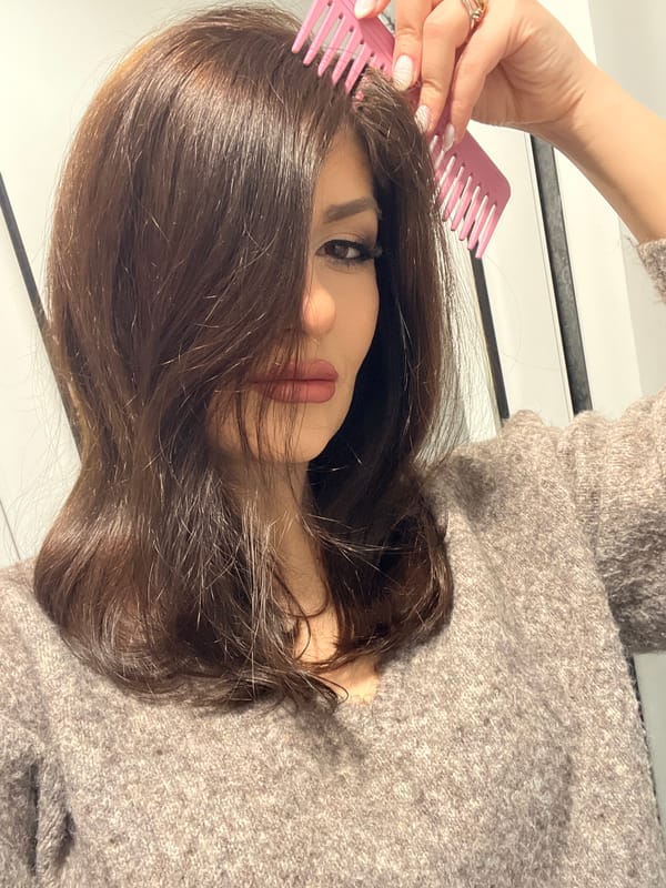 Woman styles hair with pink combs in Yambol