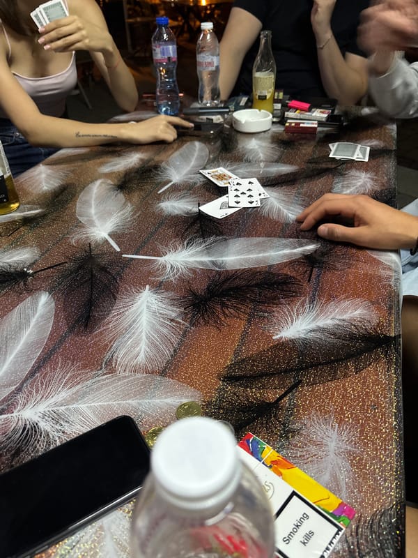 Card game around a feather-patterned table in Nedelino