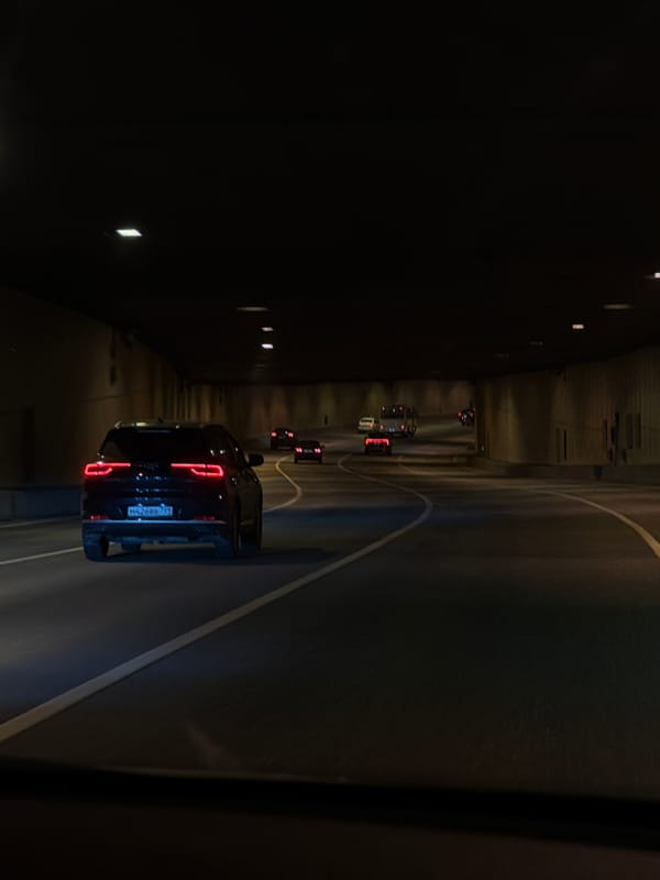 Vehicle travels through illuminated tunnel in Moscow evening