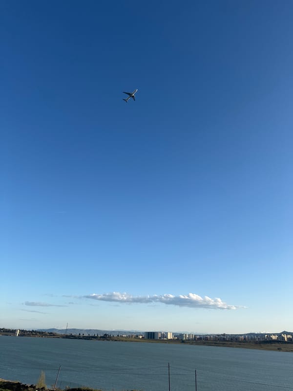 Aircraft observed flying over Tbilisi with contrail visible