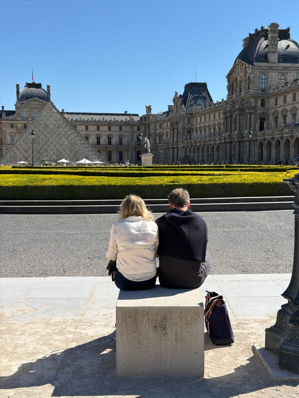 Heavy tourist crowds queue at Louvre Museum on sunny Paris afternoon