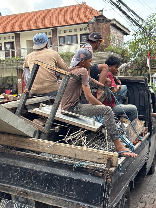 Men transport scrap materials by pickup truck in Ubud