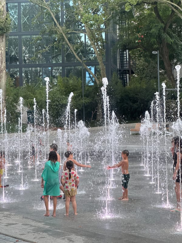 Kids cool off at a Tbilisi splash pad on a summer day