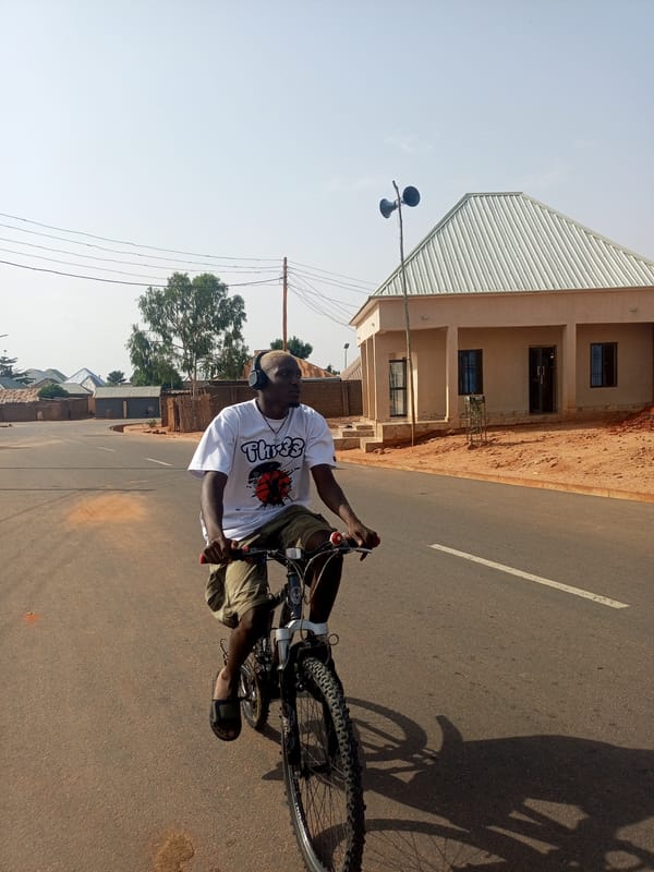 Cyclist and pedestrian share quiet road in Tempure, Nigeria