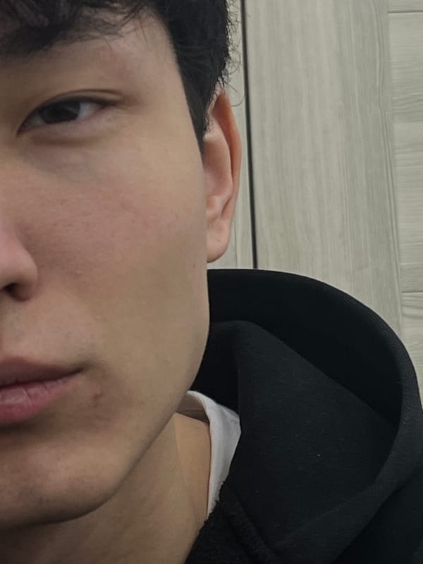 Person in black hoodie uses smartphone indoors during evening