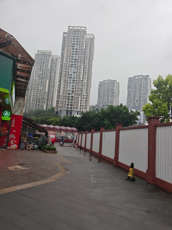 Motorcycles with umbrellas line wet Chongqing streets after rain