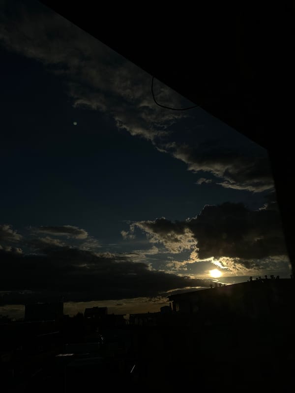 Dramatic sunset photographed over city skyline during evening hours