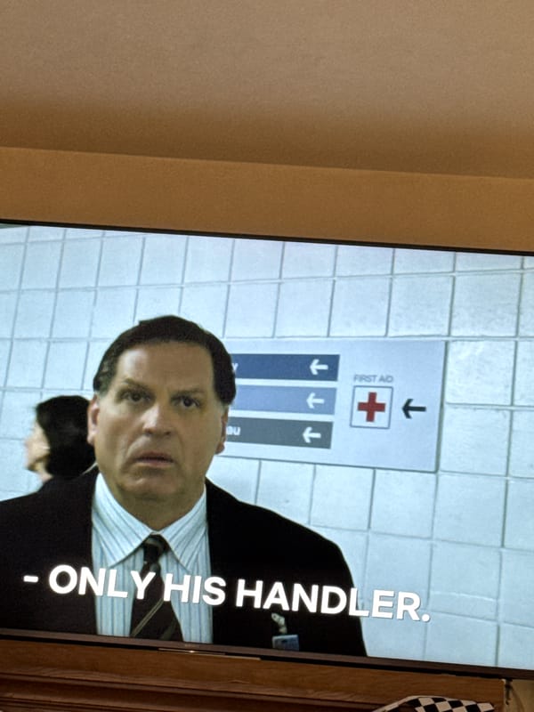 Television broadcast shows man near first aid signage