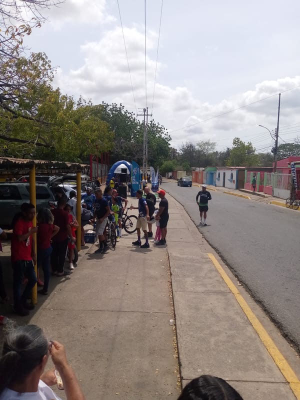People gather with bicycles on Las Barrancas sidewalk