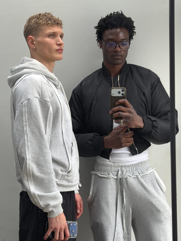 Two men take mirror selfies in London indoor setting