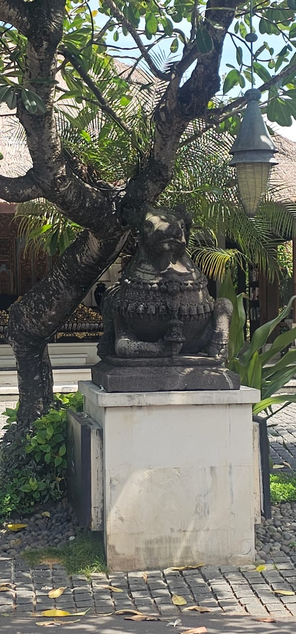 Tourist documents Balinese temple complex and tropical surroundings in Denpasar