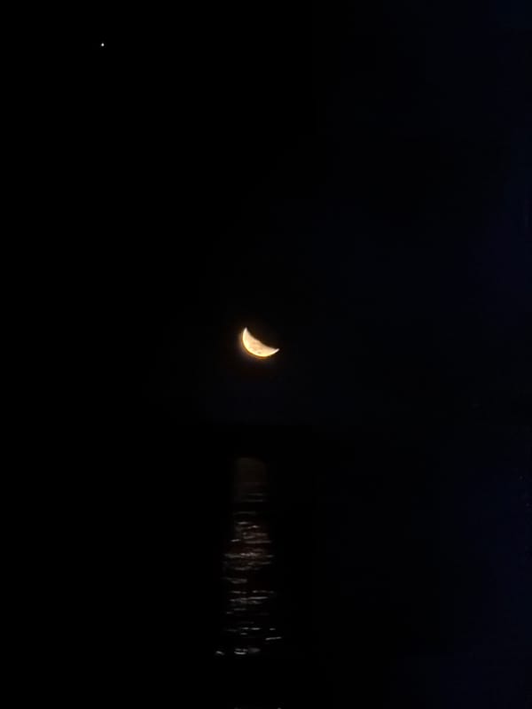 Crescent moon observed over Cape Town with water reflections