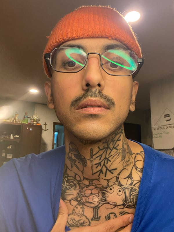 Tattooed man takes selfie in Ushuaia room