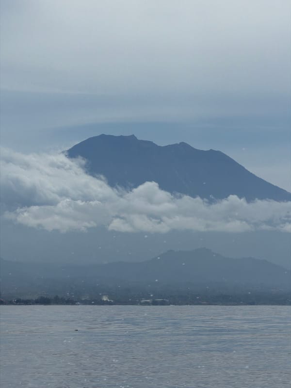 Clouded mountain observed across calm Indonesian waters early morning