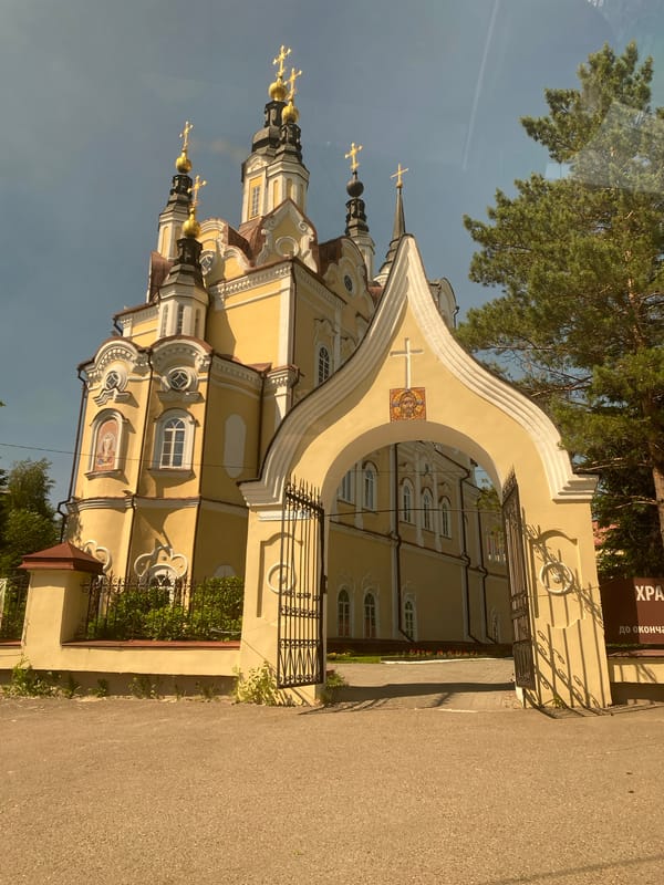 Yellow Orthodox church with golden domes in Tomsk, Russia