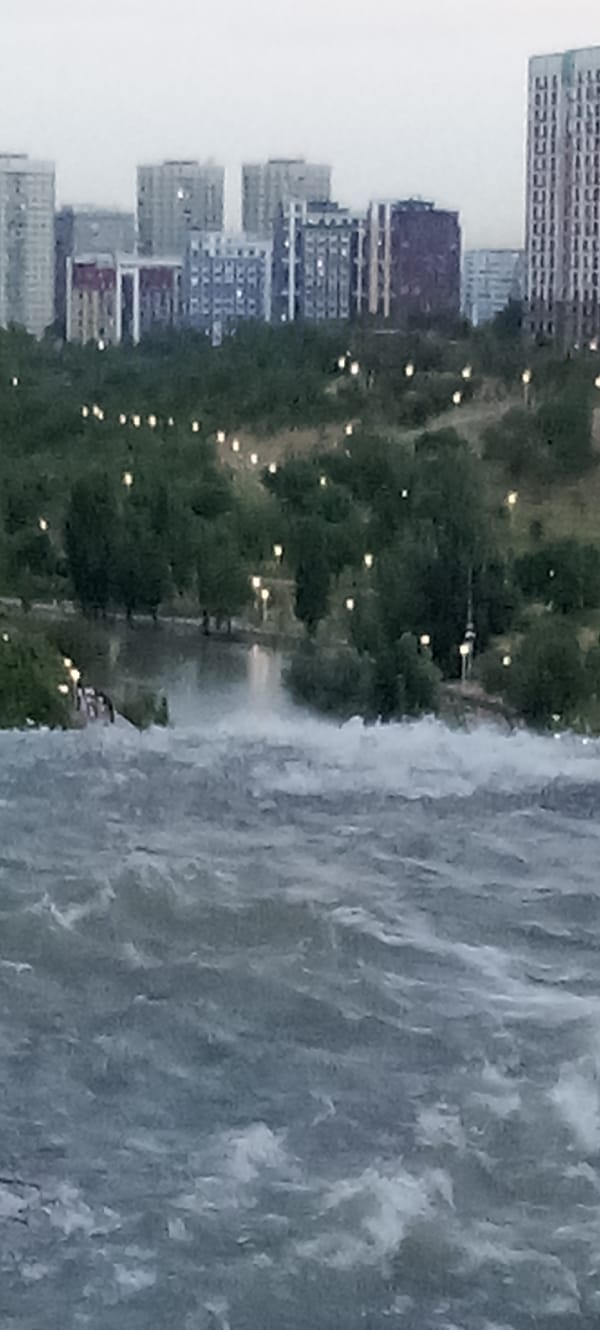 Turbulent river and waterfall running through urban Almaty
