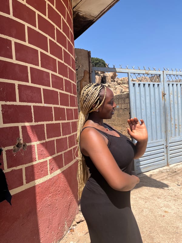 Woman in black photographed on brick surface near gate
