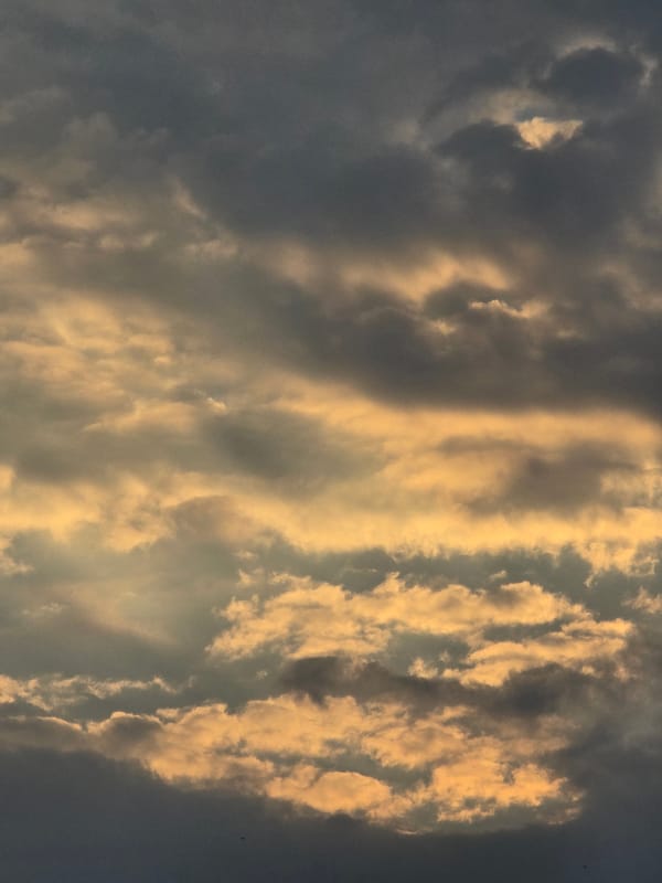 Dramatic cloud formations roll over Vilnius at golden hour.