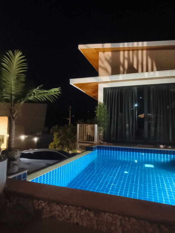 Nighttime resort pool glowing with underwater lights