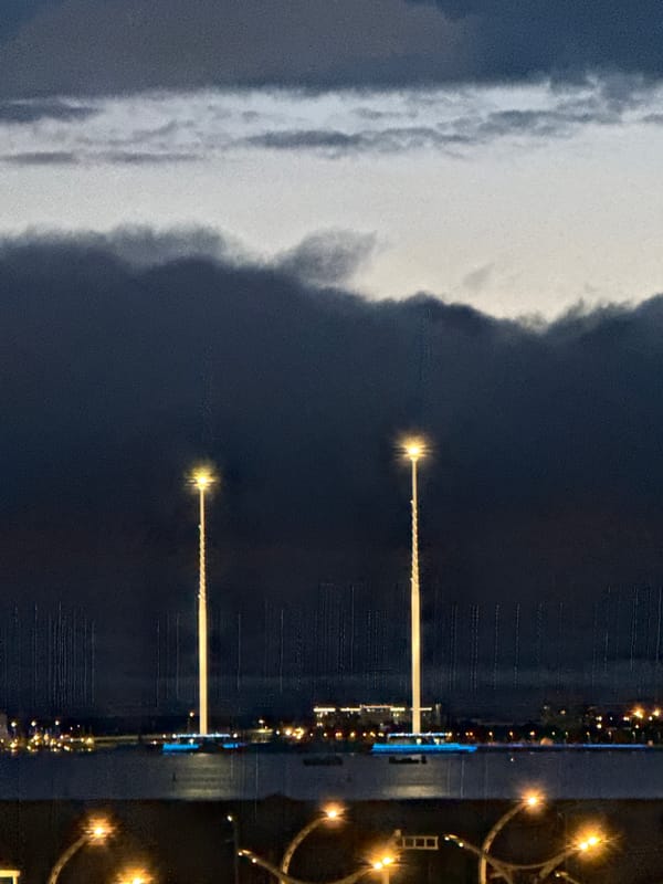 Lakhta Center and Gazprom Arena glow blue under stormy skies