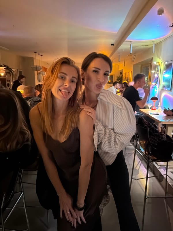 Two women enjoy drinks and photos at Krasnoyarsk restaurant