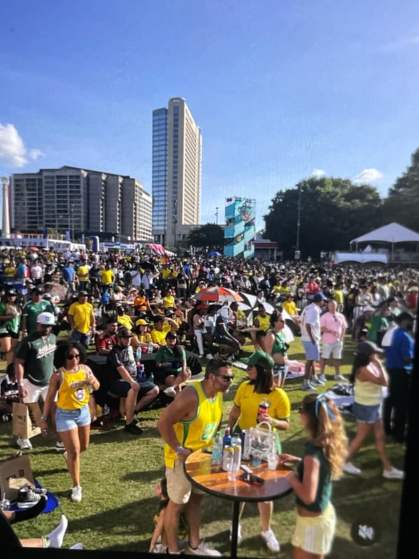 Large crowd gathers in urban park wearing yellow and green