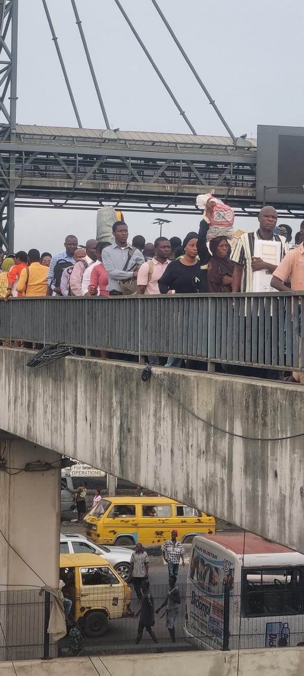 Morning crowds gather on Lagos bridges, damaged vehicle spotted